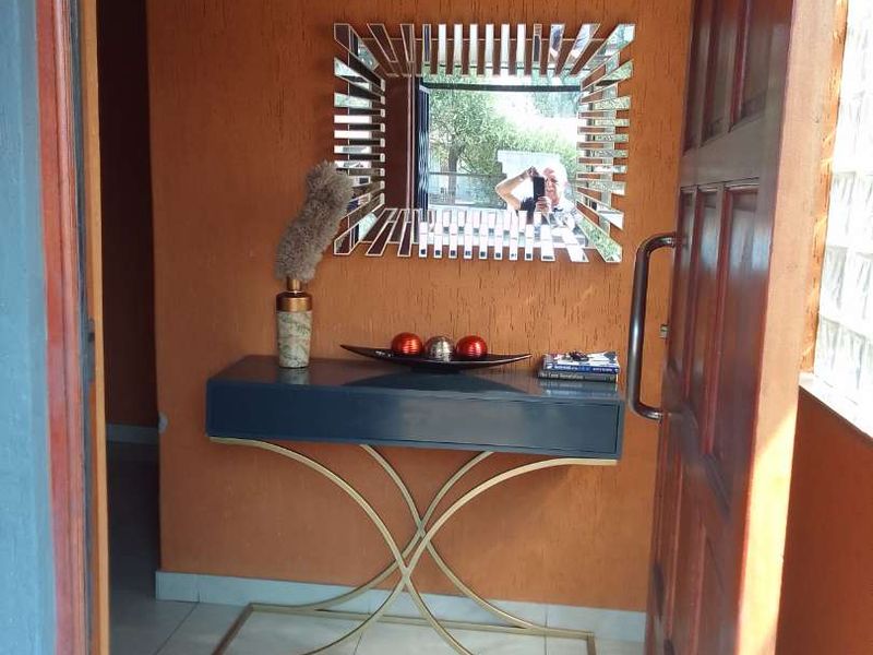 An inviting entryway featuring tiled flooring and a solid timber entrance door, providing a warm welcome to the home.