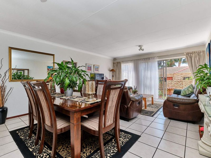 Open-plan living and dining area featuring tiled flooring and a sliding glass door providing access to the outdoor space.