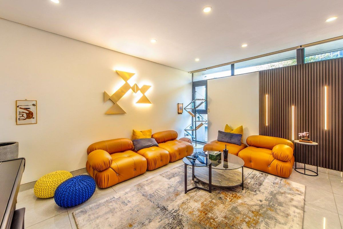 Modern living room featuring sleek tiled flooring, decorative slatted timber wall paneling, integrated accent lighting, and high-level clerestory windows for natural light.