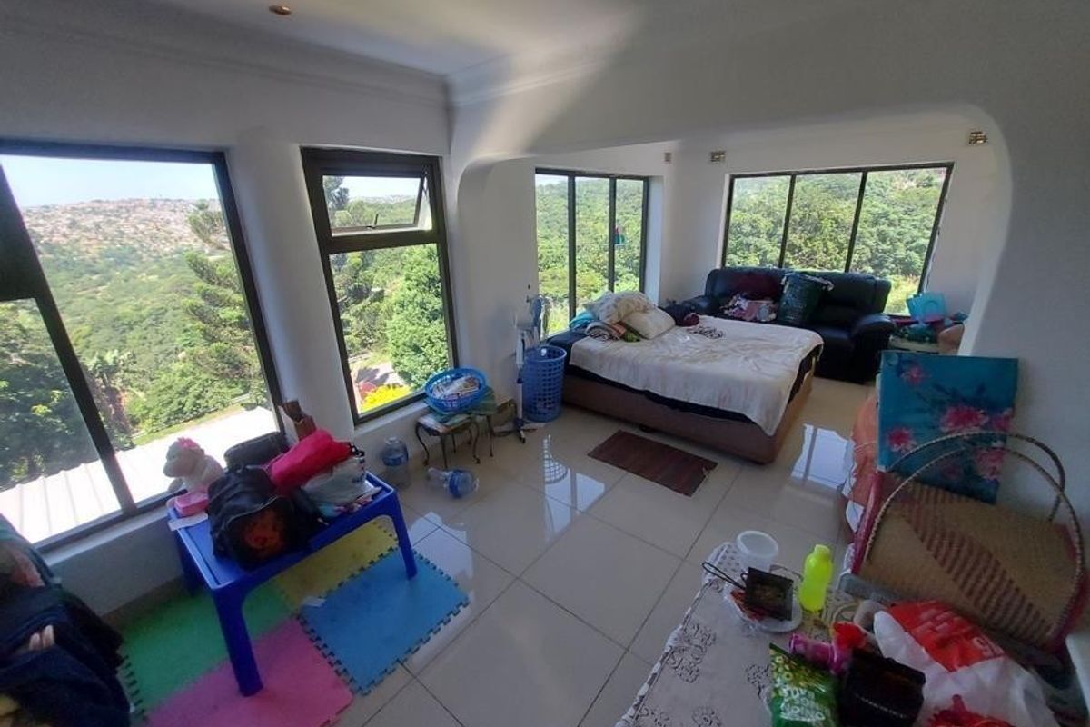 A bedroom featuring large windows with scenic views, tiled flooring, and recessed ceiling lighting.