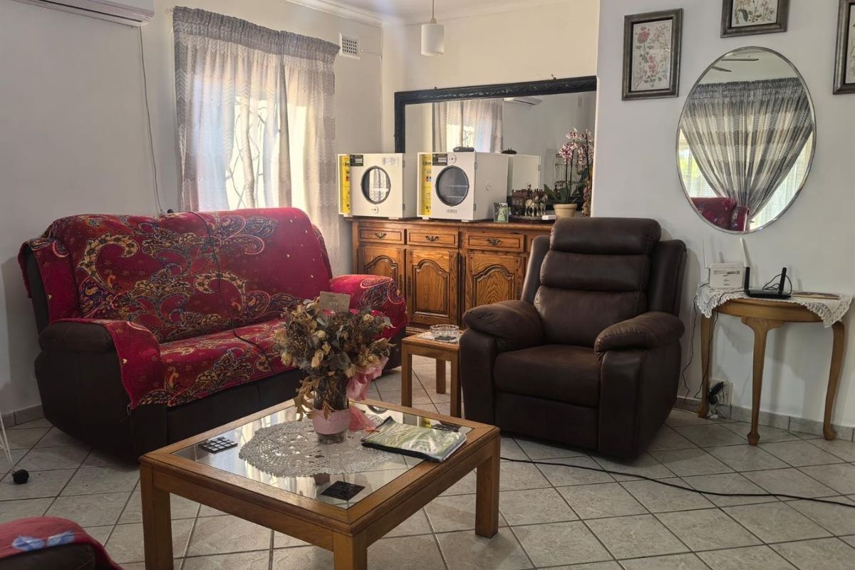 A living room featuring tiled flooring, an air conditioning unit, and built-in wooden cabinetry, providing a functional and comfortable living space.
