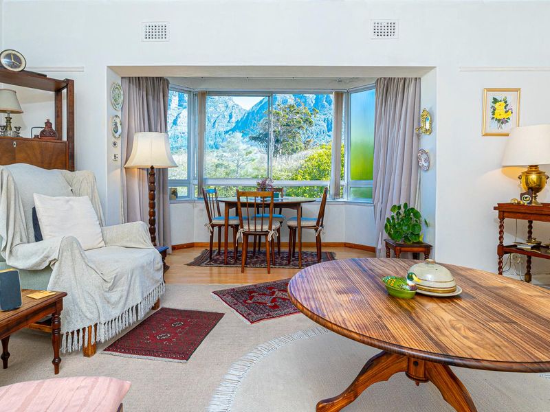 A comfortable living room featuring a large bay window with scenic mountain views, providing ample natural light and a pleasant outlook.