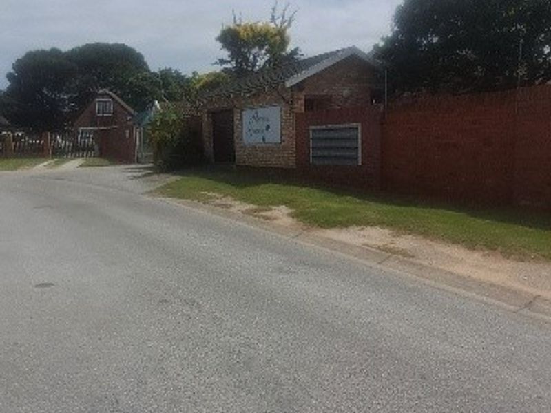 Street view of the property showing the brick boundary wall, entrance area, and integrated post boxes.
