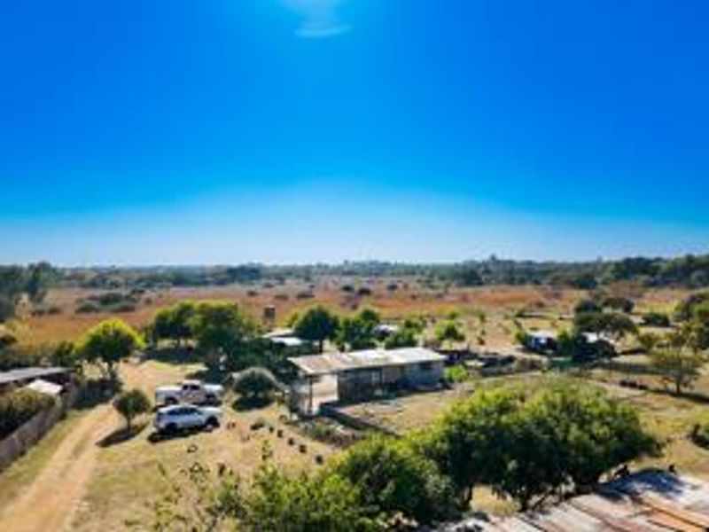 An aerial view of the small holding property, showcasing the expansive grounds, mature trees, water storage infrastructure, and surrounding landscape.