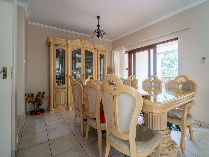 A dining room featuring tiled flooring, a ceiling pendant light, and a sliding glass door providing access to an outdoor area.