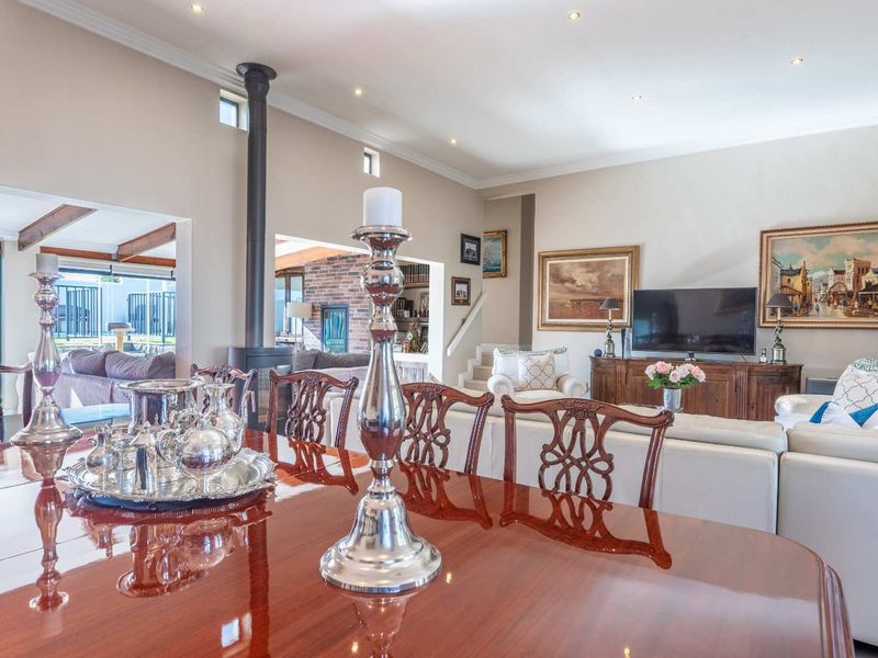 Spacious open-plan living and dining area featuring a modern freestanding fireplace, recessed lighting, and seamless flow to the outdoor patio space.