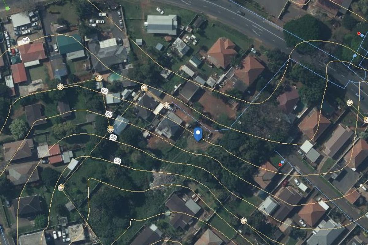 An aerial view of a residential plot featuring overlaid topographic contour lines indicating the elevation profile of the land.