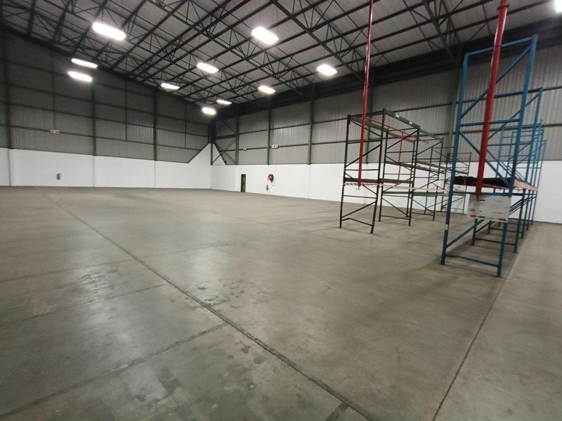 Spacious industrial warehouse unit featuring high ceilings, exposed steel trusses, durable concrete flooring, and integrated fire suppression systems.