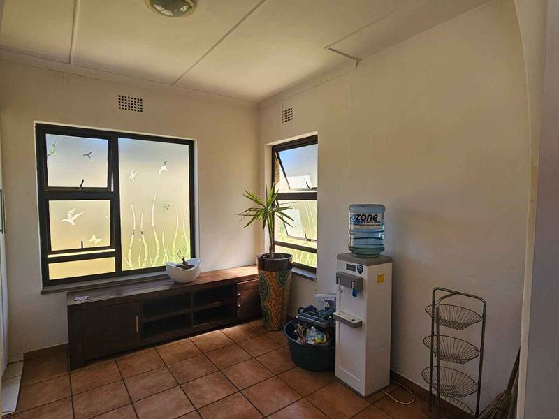 A bright living area featuring tiled flooring and large windows with frosted glass, providing natural light and a neutral foundation for interior design.