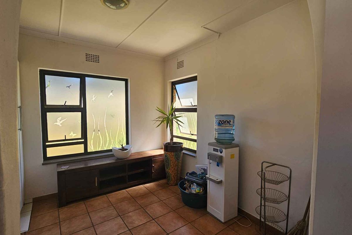 A bright living area featuring tiled flooring and large windows with frosted glass, providing natural light and a neutral foundation for interior design.