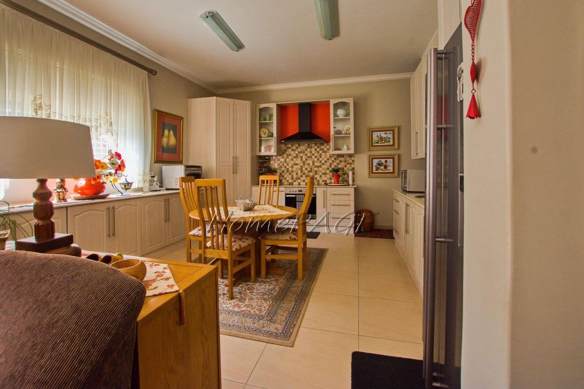 A functional kitchen featuring tiled flooring, built-in cabinetry, a tiled backsplash, and a modern extractor fan.