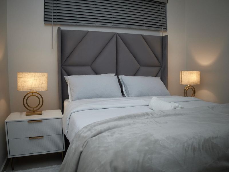 A well-presented bedroom featuring neutral wall tones and fitted venetian blinds, creating a comfortable and modern sleeping environment.