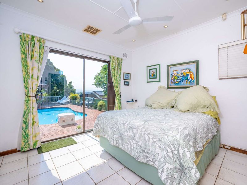 Bedroom featuring tiled flooring, a ceiling fan, and sliding glass doors providing direct access to the outdoor pool area.