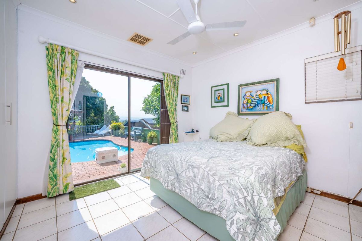 Bedroom featuring tiled flooring, a ceiling fan, and sliding glass doors providing direct access to the outdoor pool area.