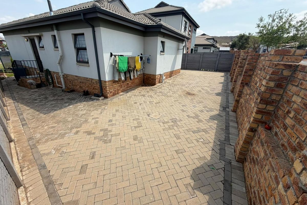 A paved rear courtyard area featuring brick boundary walls and a well-maintained exterior facade with tiled roofing.