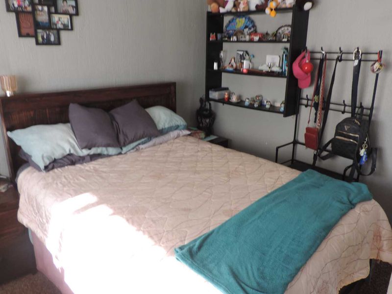 A standard bedroom featuring neutral wall finishes and carpeted flooring.