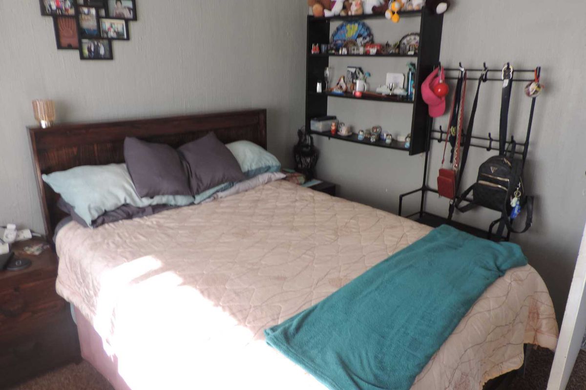 A standard bedroom featuring neutral wall finishes and carpeted flooring.