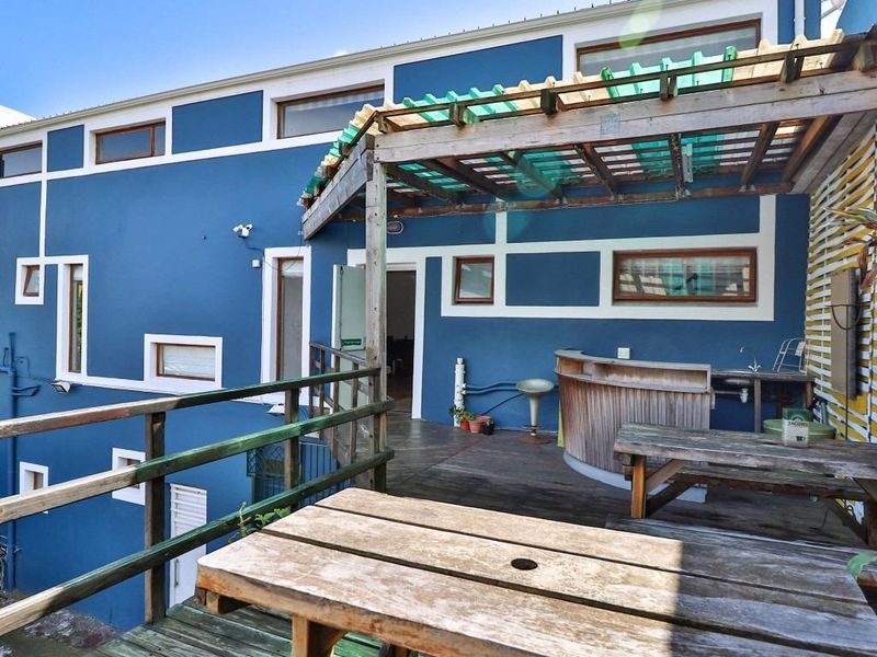 Outdoor patio area featuring timber decking, a built-in bar counter with sink, and a timber pergola structure.