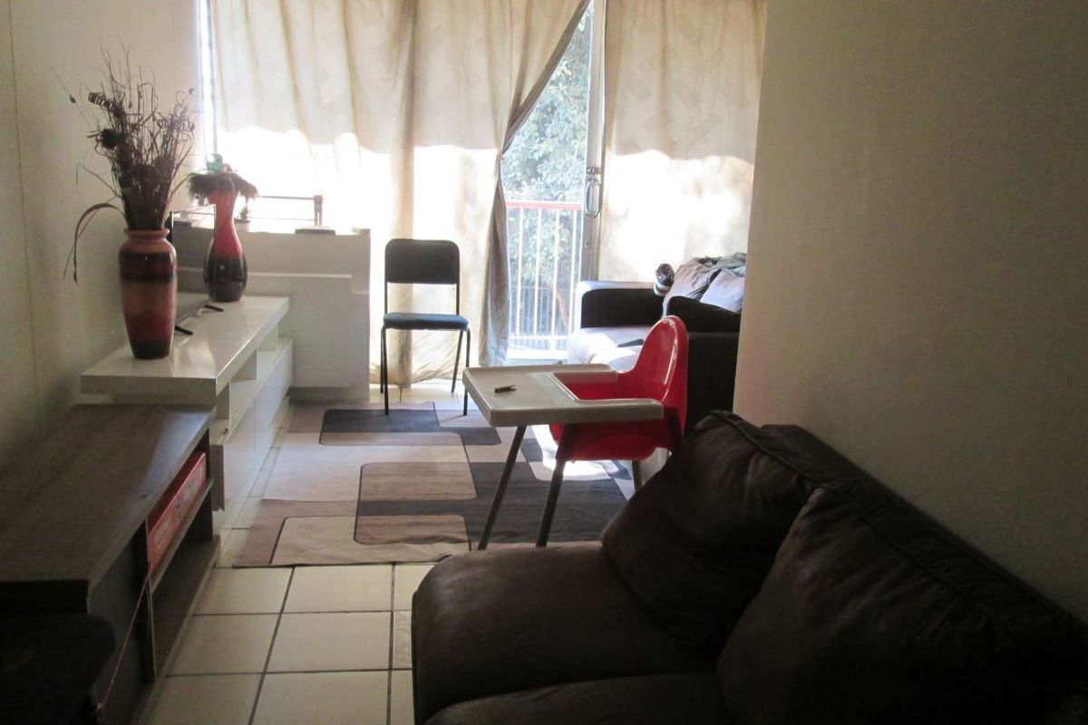 A living room area featuring tiled flooring and a sliding glass door leading to an outdoor space.