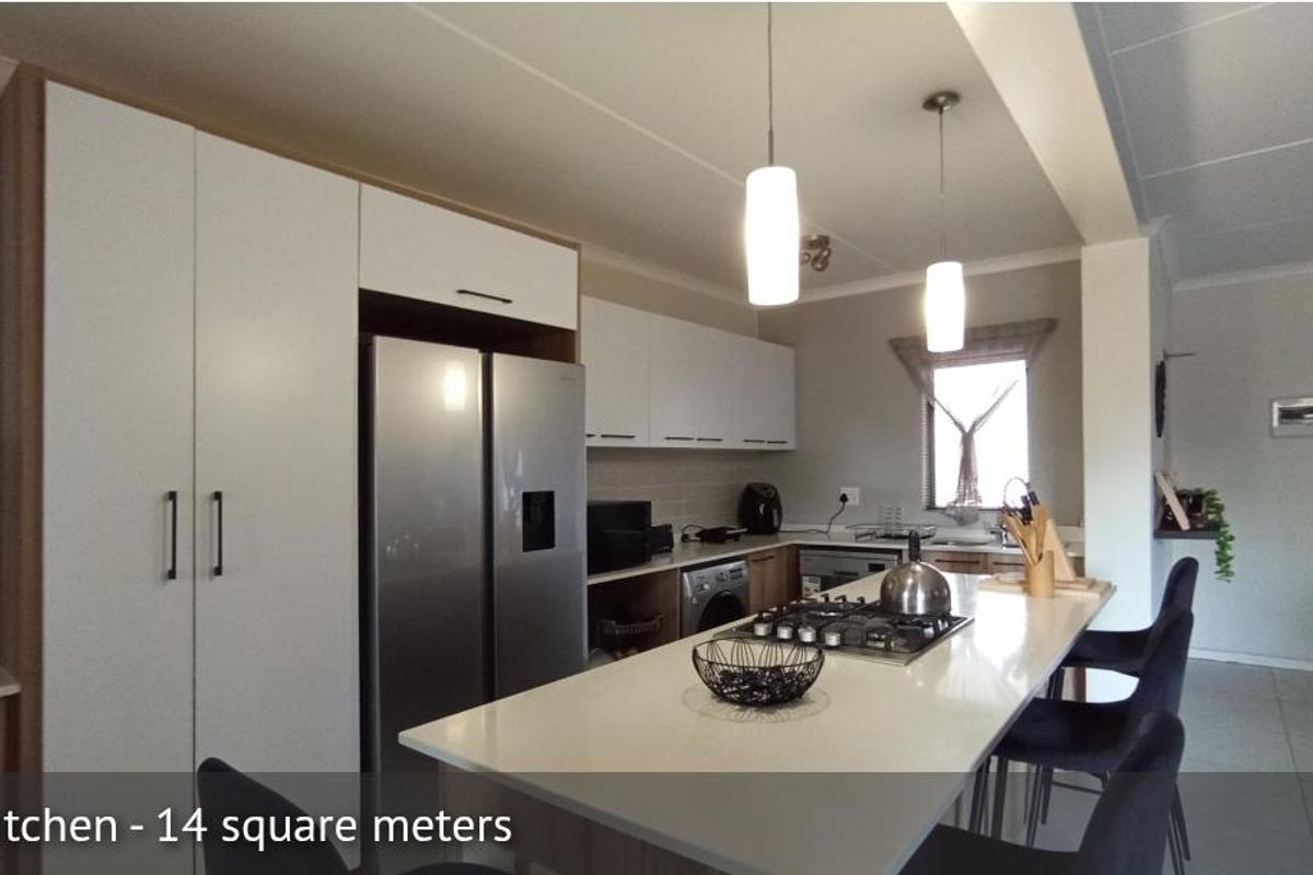 Modern kitchen featuring a central island with a built-in gas hob, sleek cabinetry, and integrated appliances, offering a functional and contemporary cooking space.