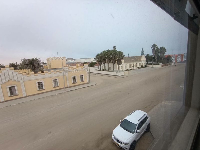 An elevated street view looking out over a sandy road and surrounding historic architecture.