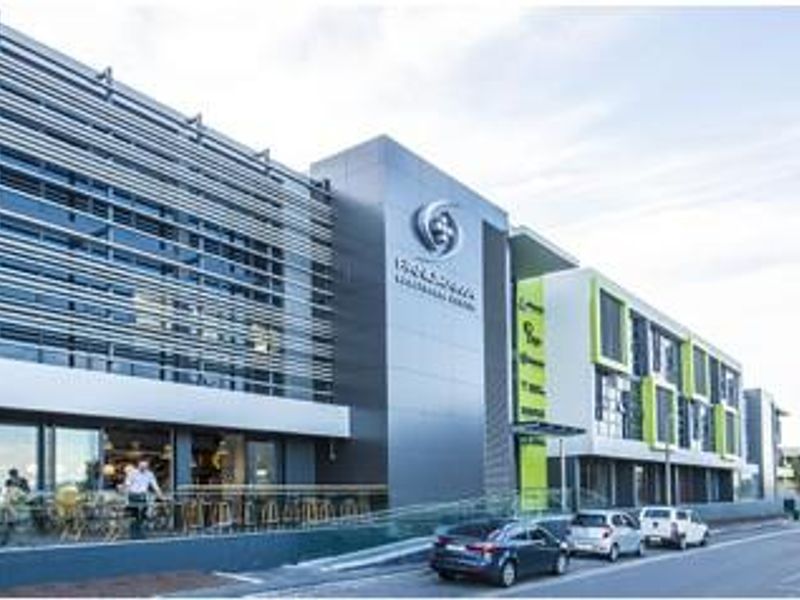 Modern commercial office building facade featuring contemporary architectural design, extensive glass frontage, and integrated sun shading elements.