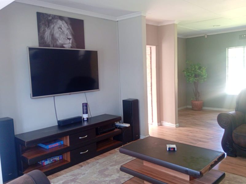 A spacious living area featuring laminate flooring and neutral wall tones, providing a comfortable and versatile space for relaxation.