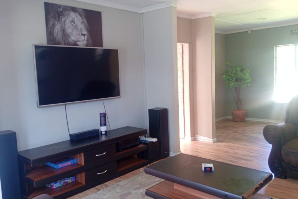 A spacious living area featuring laminate flooring and neutral wall tones, providing a comfortable and versatile space for relaxation.