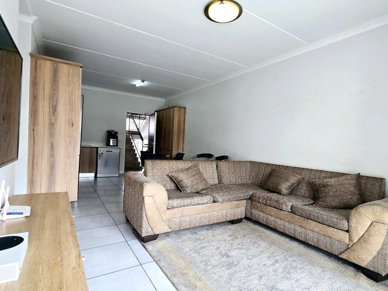 Open-plan living area featuring tiled flooring and a connected kitchen space, providing a functional layout for modern apartment living.