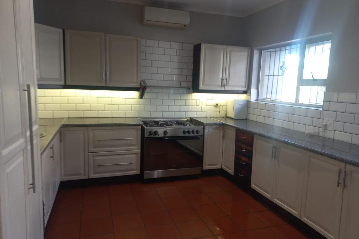 A functional kitchen featuring white cabinetry, granite countertops, subway tile backsplash, and a gas stove with an integrated oven.