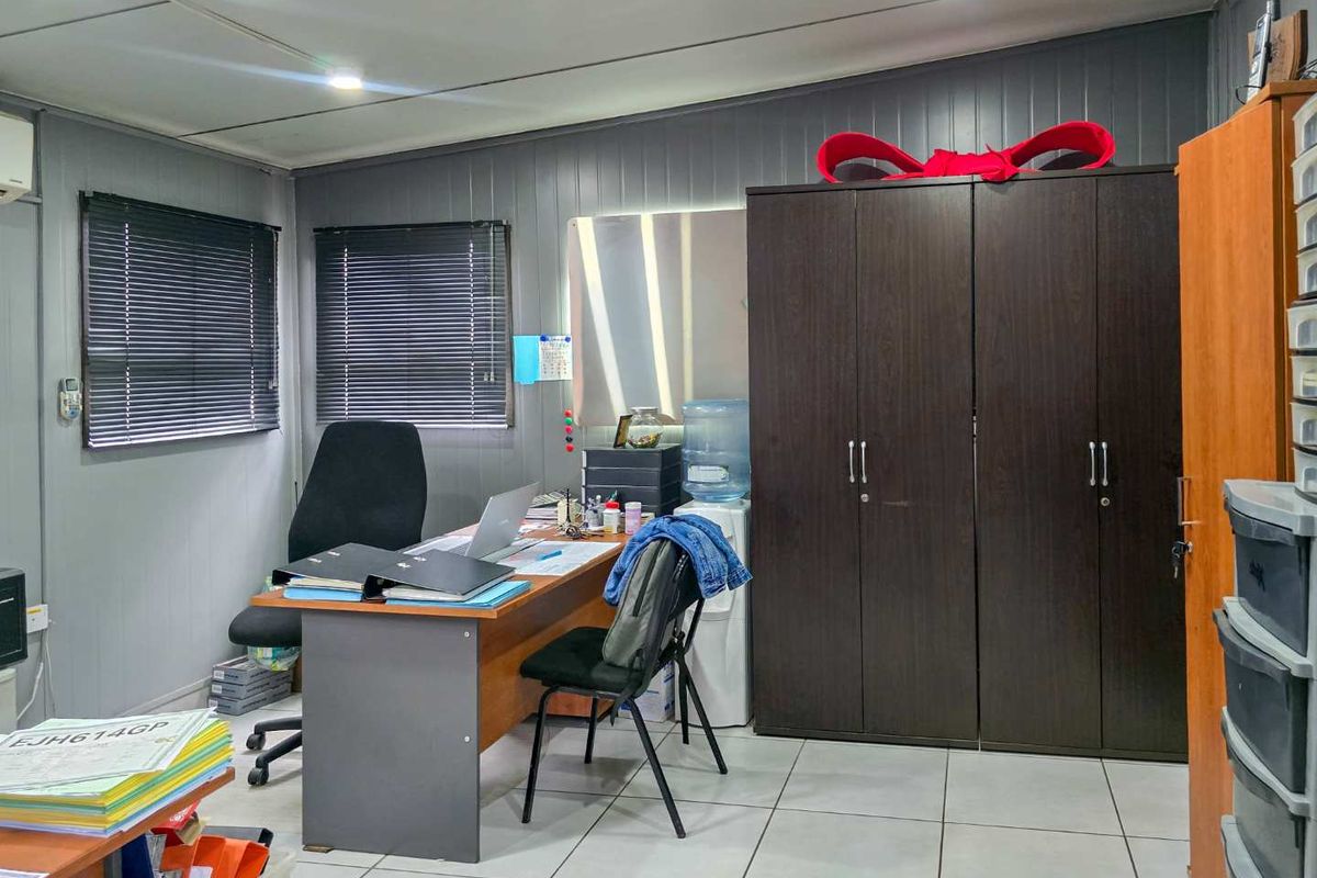 A functional office space featuring tiled flooring, recessed lighting, venetian blinds, and a built-in storage cupboard.