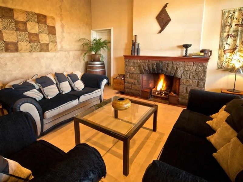 A cozy living room featuring a prominent stone fireplace and textured wall finishes, creating a warm and inviting atmosphere.