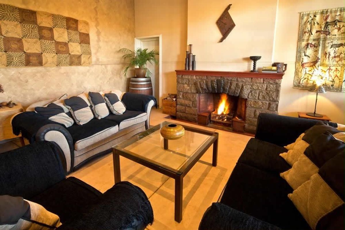 A cozy living room featuring a prominent stone fireplace and textured wall finishes, creating a warm and inviting atmosphere.