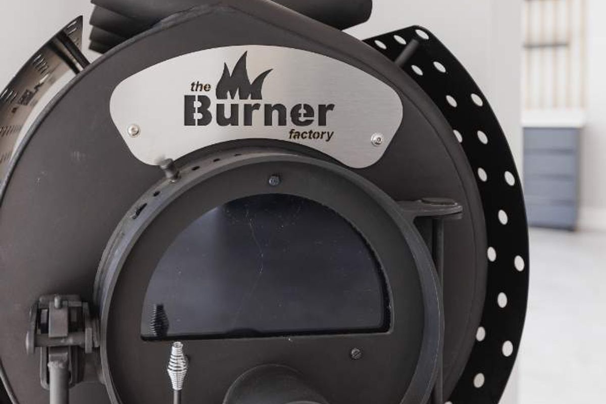 A close-up view of a modern, black metal wood-burning stove, serving as a functional heating feature within the living space.