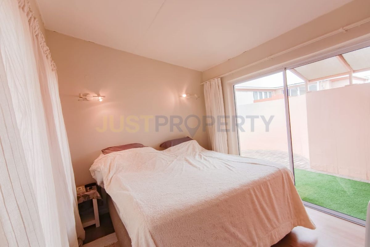 A bedroom featuring laminate flooring and a sliding glass door providing direct access to an outdoor patio area.