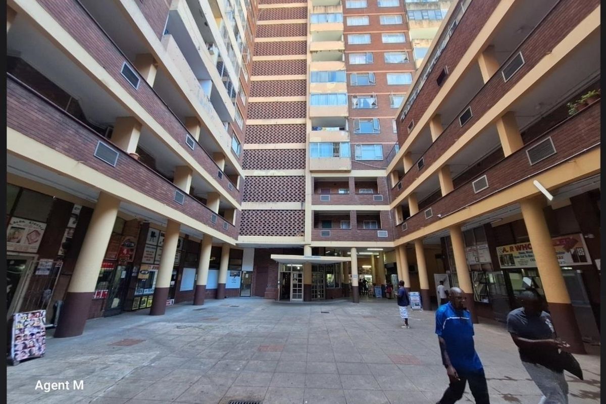 A view of the apartment building's central courtyard and entrance area, featuring multi-story brick architecture with open-air walkways.