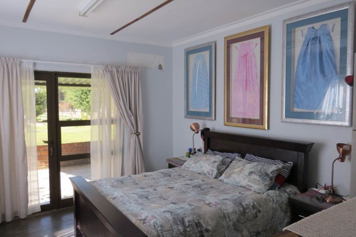 A bedroom featuring tiled flooring, neutral wall finishes, and a sliding glass door providing direct access to the outdoor patio area.