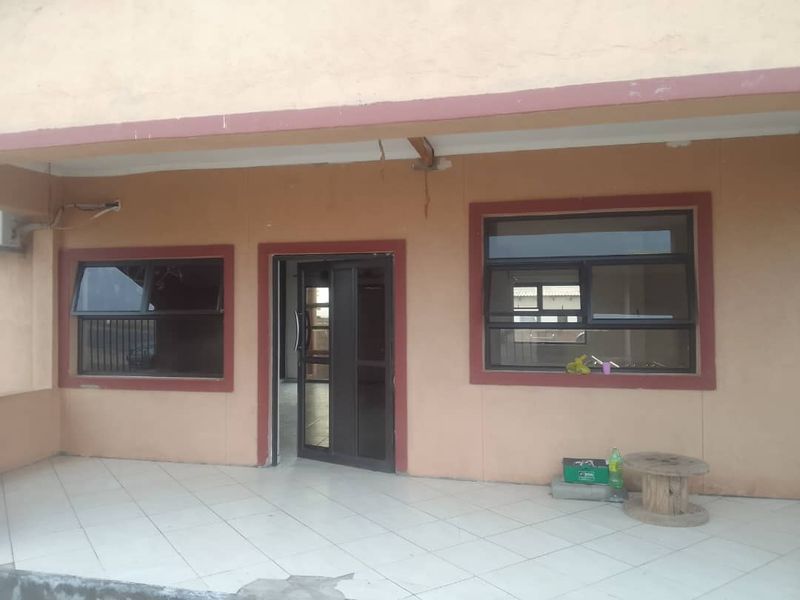 A covered patio area featuring tiled flooring and aluminium window and door frames, showing signs of wear and maintenance requirements.
