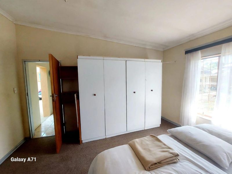A bedroom featuring a built-in wardrobe, carpeted flooring, and coved ceiling, offering a functional space with potential for cosmetic updates.