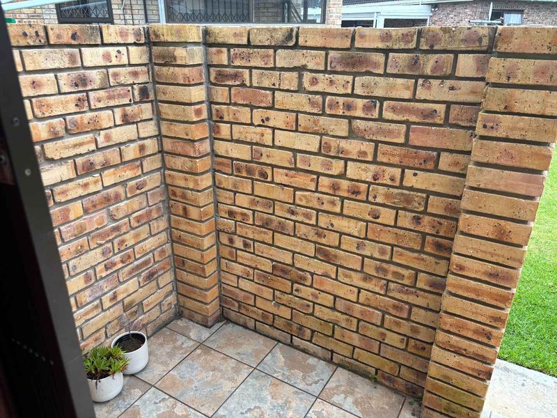 A private, enclosed patio area featuring durable face brick walls and tiled flooring, providing a secure and low-maintenance outdoor space.