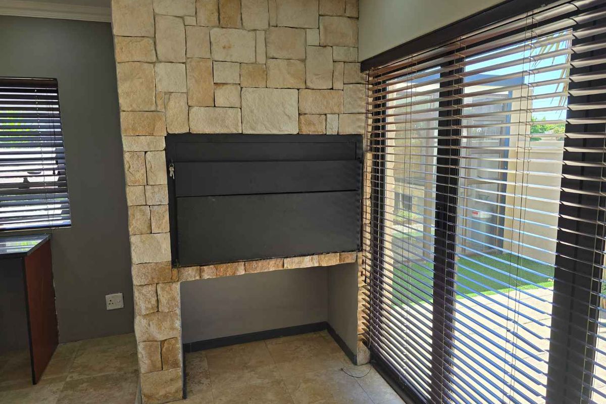 A living area featuring a prominent stone-clad built-in fireplace and large sliding glass doors that provide access to the outdoor space.
