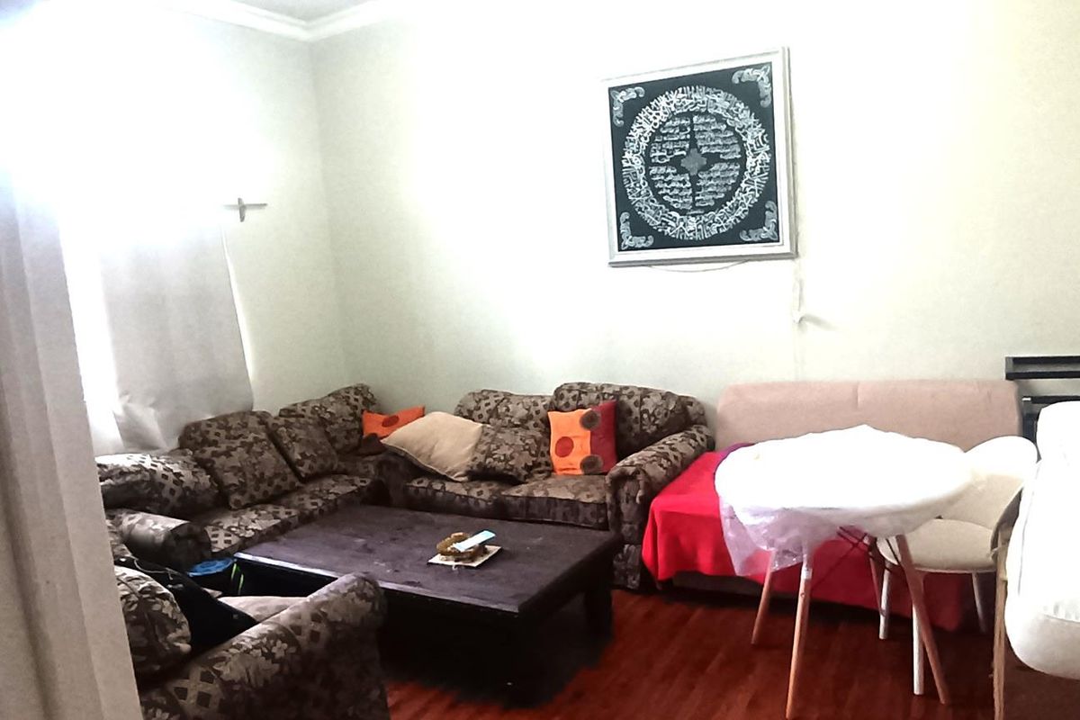 A living room area featuring hardwood flooring and coving, providing a functional space for relaxation and dining.
