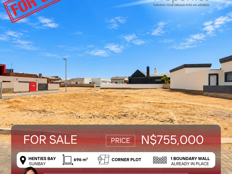 A vacant residential corner plot in Henties Bay, featuring an existing boundary wall and street access, ready for development.