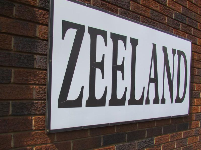 A close-up view of the Zeeland building signage mounted on a brick exterior wall.