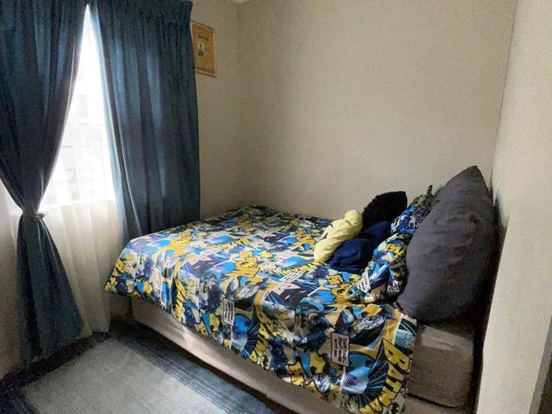 A compact bedroom featuring tiled flooring and coved ceiling details, providing a functional space for a single bed.