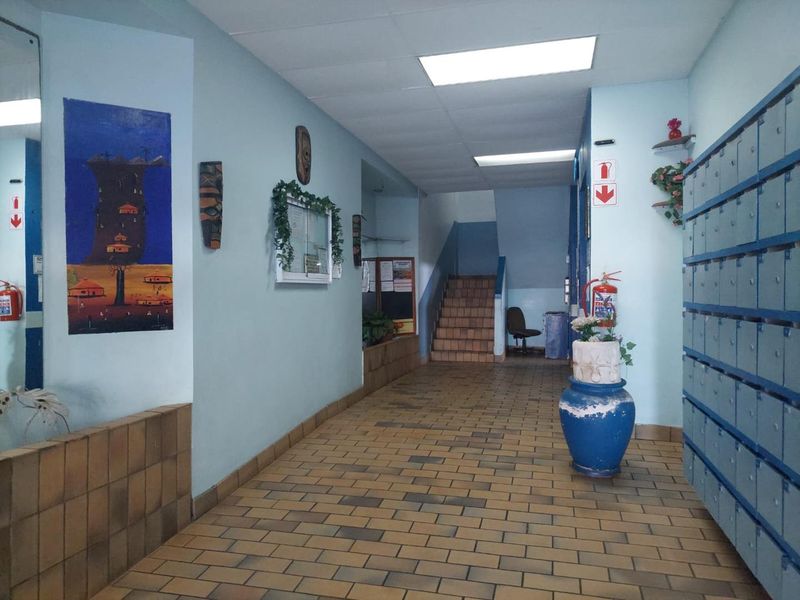 Apartment building entrance hallway featuring tiled flooring, built-in mailboxes, and access to the staircase.