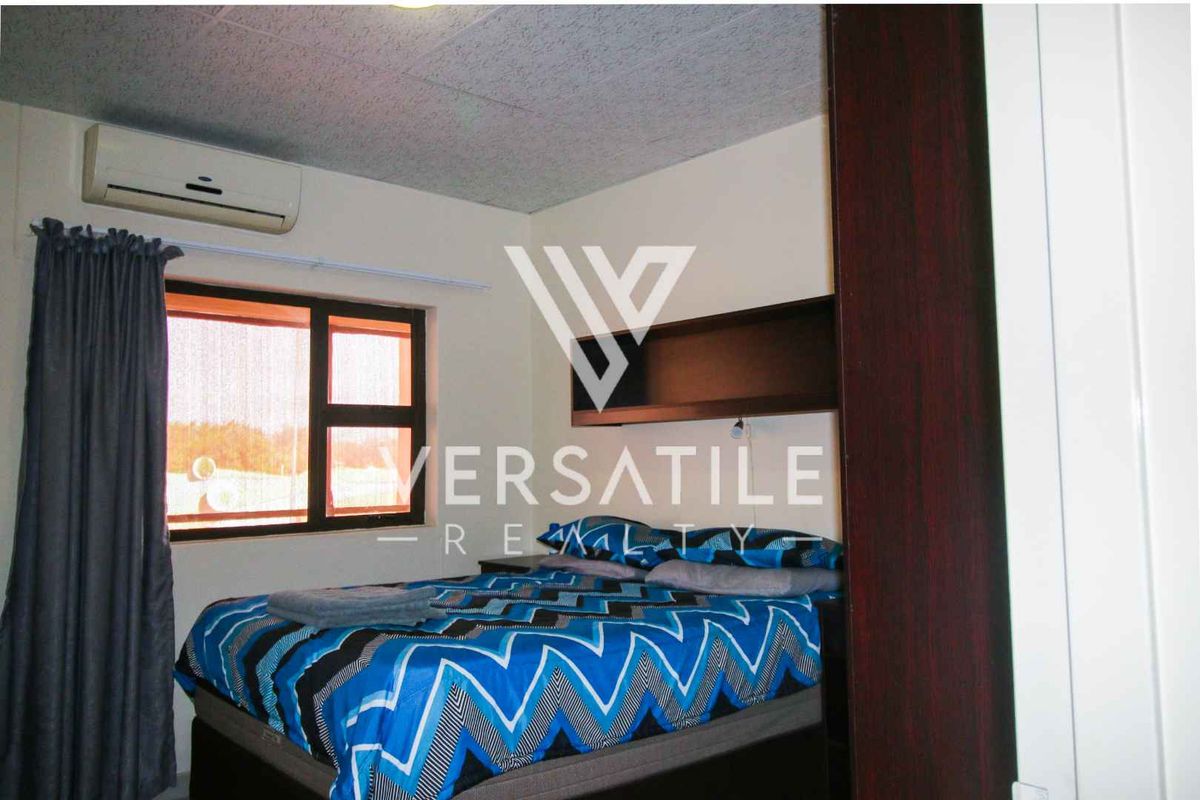 A bedroom featuring a built-in wardrobe and a wall-mounted split-system air conditioning unit.