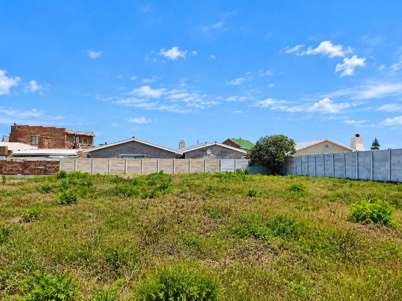 A vacant residential plot featuring established boundary walls and surrounding neighborhood properties, offering a clear space for future development.