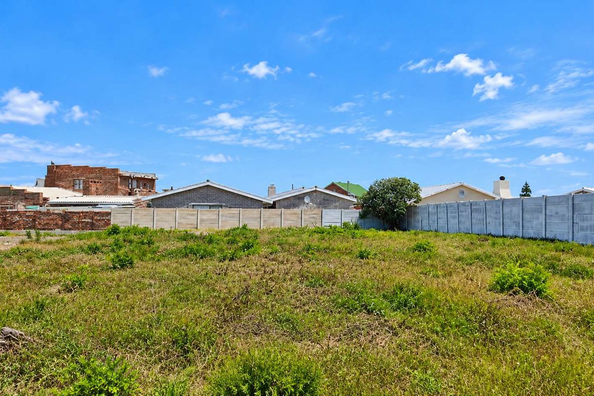 A vacant residential plot featuring established boundary walls and surrounding neighborhood properties, offering a clear space for future development.