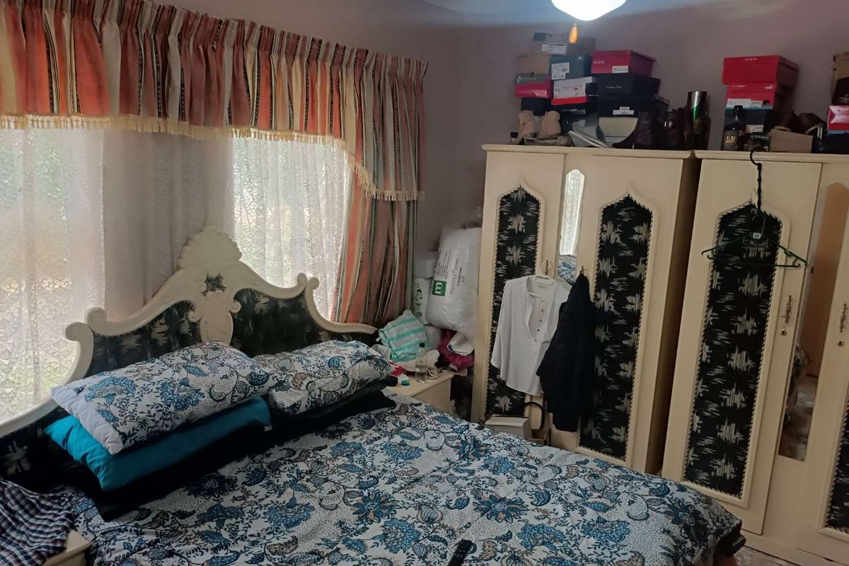 A bedroom featuring a built-in wardrobe and natural light through the window.